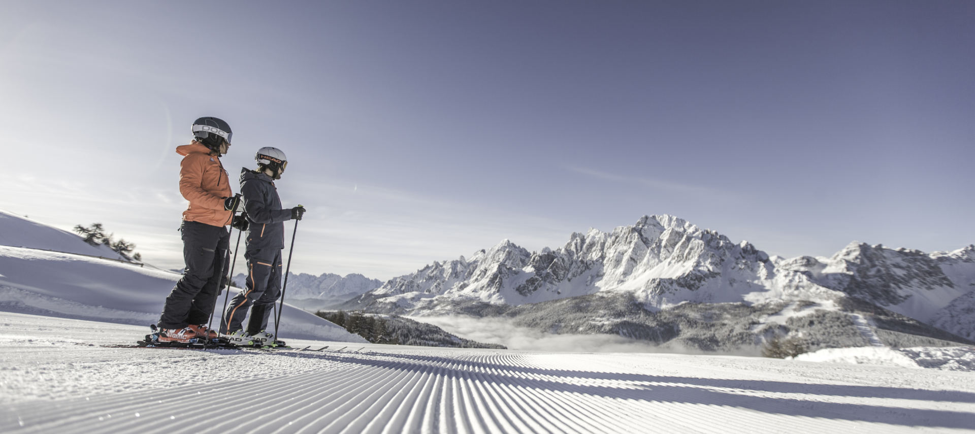 Zwei Skifahrer vor Bergpanorama in den Dolomiten