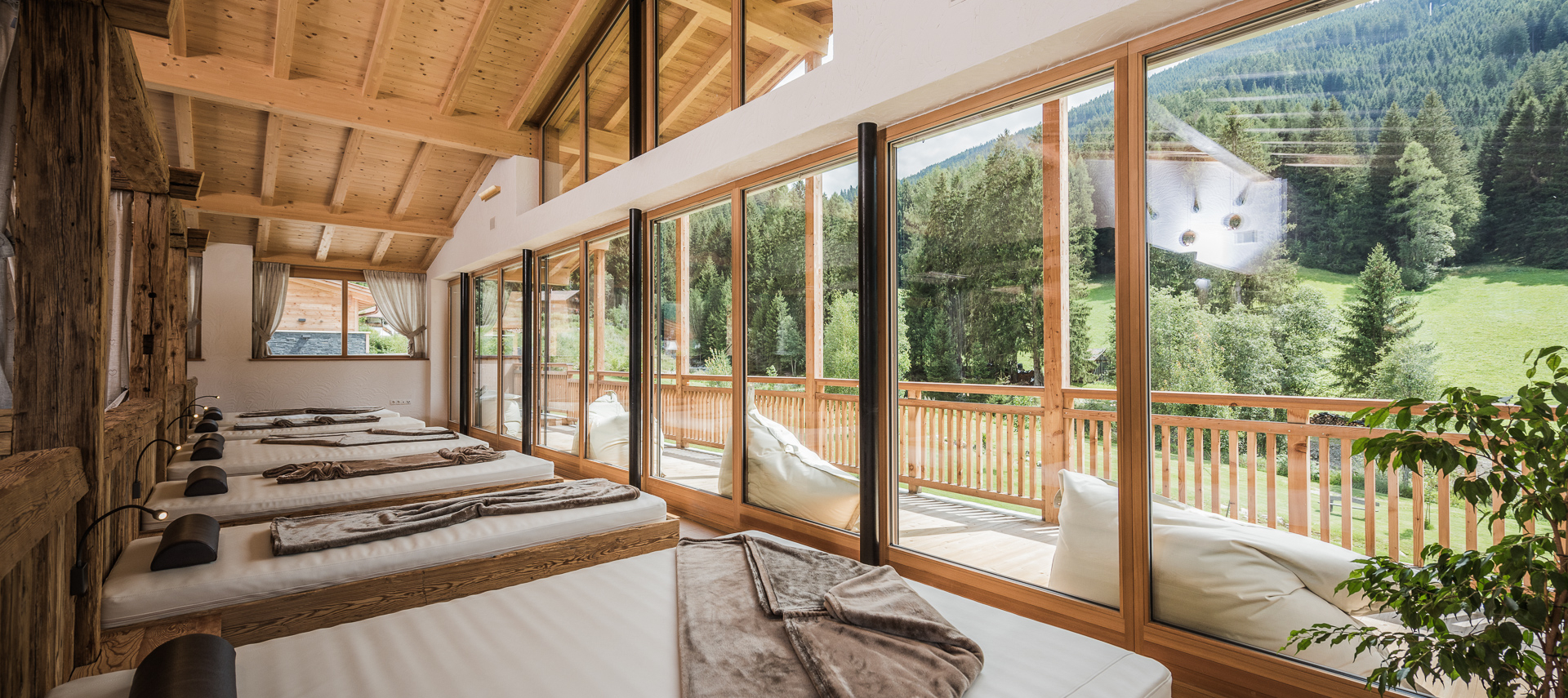 Wellness Ruheraum mit Blick auf bewaldete Berge im Gsieser Tal